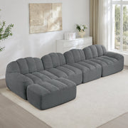 Divano modulare a 4 posti con ottoman; forma ergonomica e rivestimento in pile granulato grigio