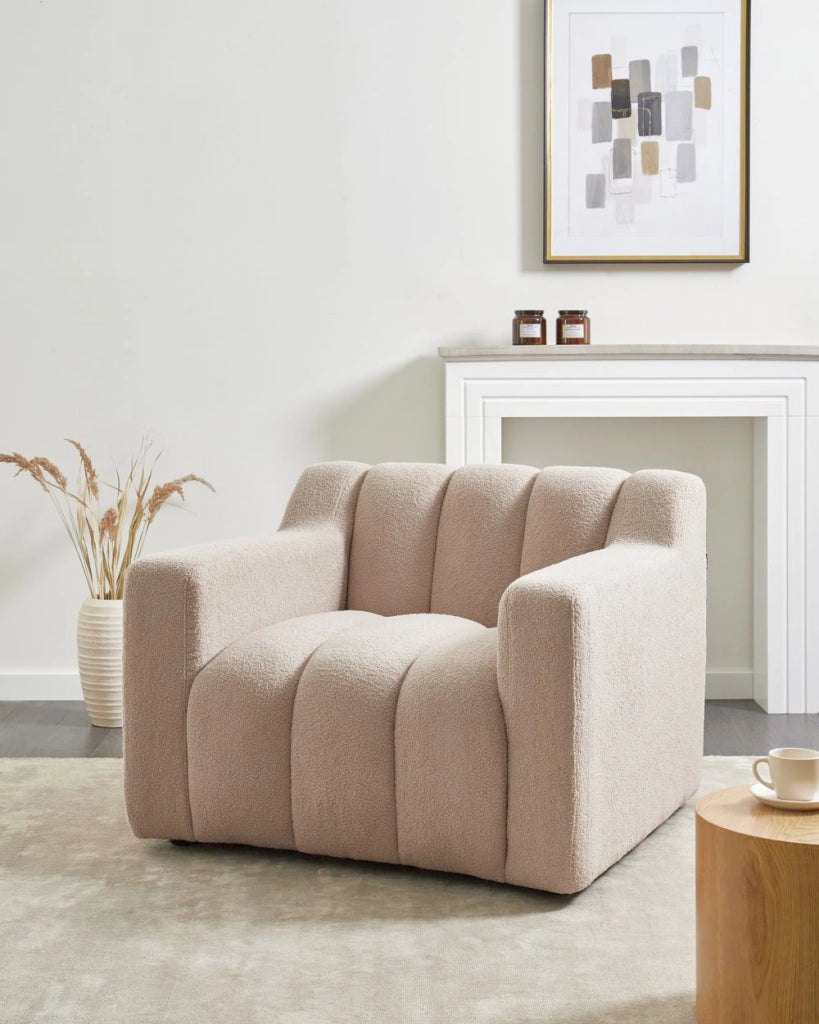 Poltrona con rivestimento in bouclé beige schienale imbottito e cuscini spessi perfetta per un soggiorno moderno