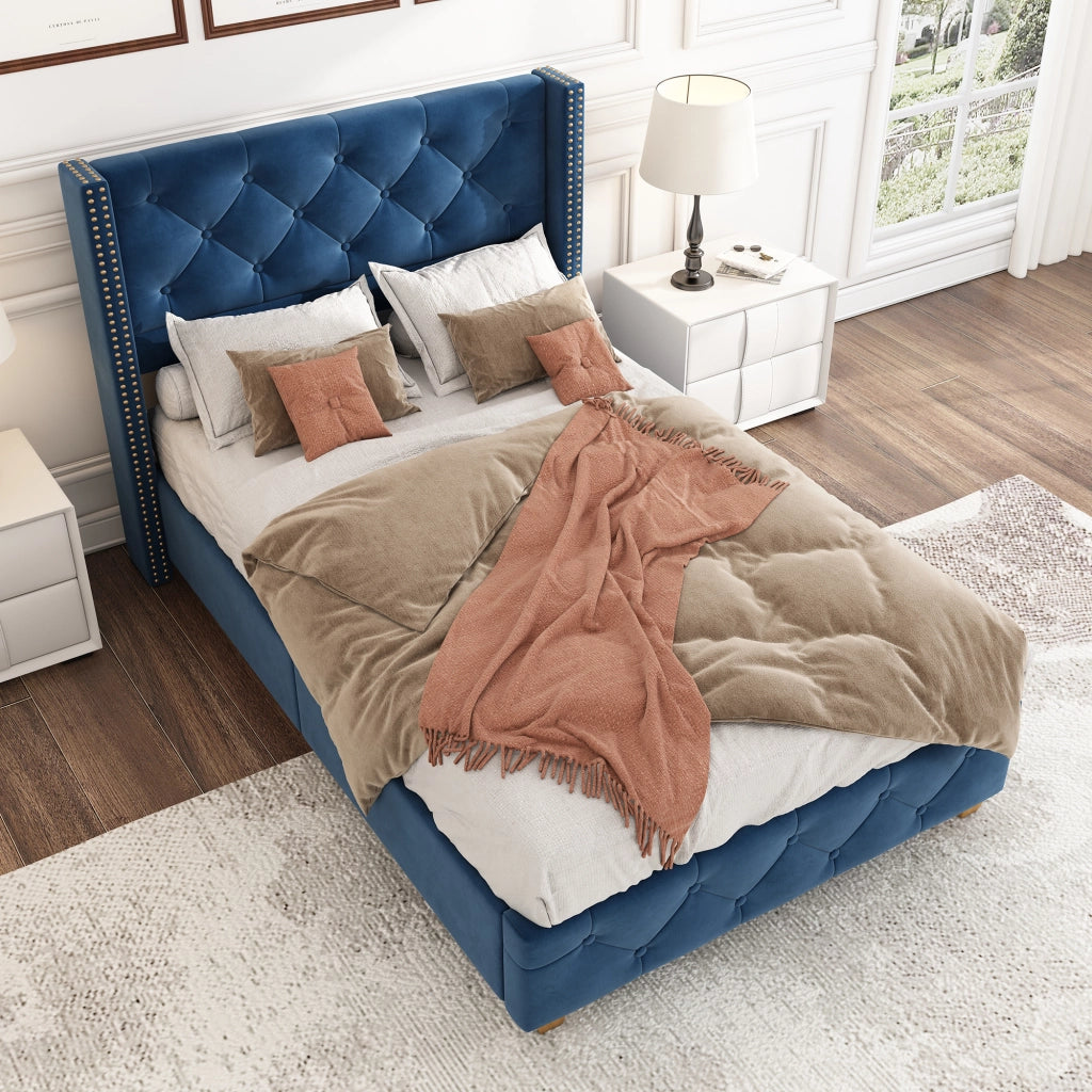 Letto imbottito con testiera capitonné; rivetti decorativi e gambe in legno; velluto blu; 90x200 cm