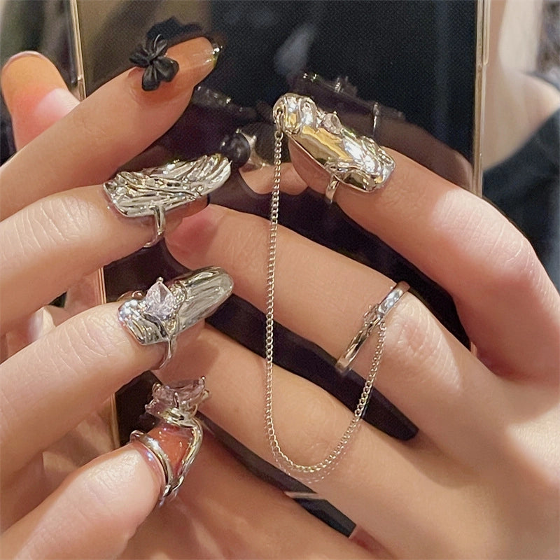 Un set di quattro pezzi composto da anelli per unghie, protezioni per unghie e manicotti per dita, eleganti e alla moda.