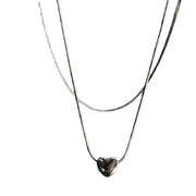 Collana minimalista a forma di cuore in acciaio al titanio con catena a osso di serpente.