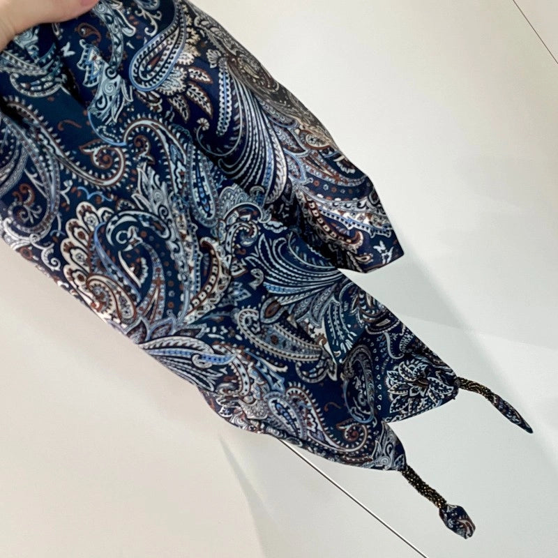 Cintura decorata con sciarpa paisley blu scuro abbinata a pantaloni, jeans e gonna, sovrapposta a una sciarpa triangolare e a una patta posteriore.