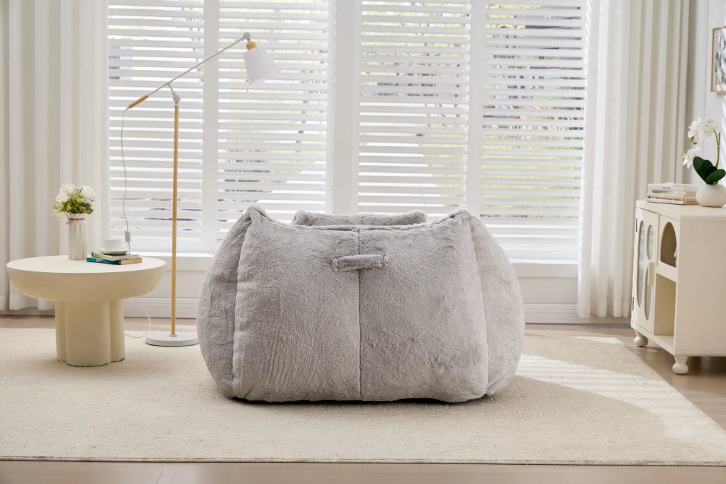 Poltrona pouf con schienale ergonomico e imbottitura in schiuma, in pelliccia sintetica grigia per soggiorno