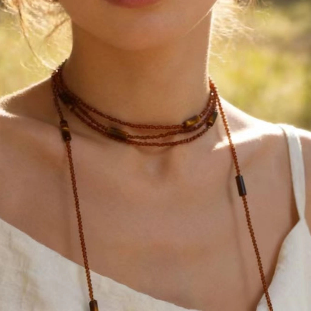 Collana girocollo lunga a pi¨´ strati con perline di cristallo marrone e pietra occhio di tigre, un accessorio di tendenza e alla moda.