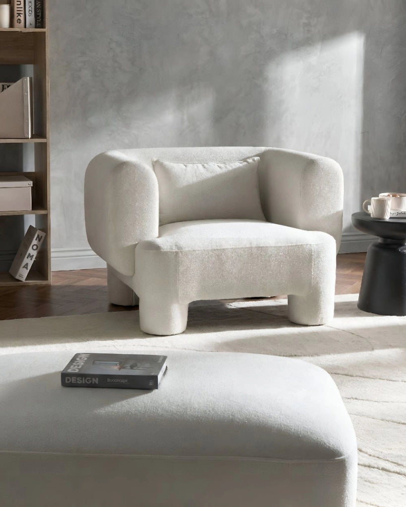 Poltrona in tessuto bianco con rivestimento in peluche, gambe cilindriche e stile organico