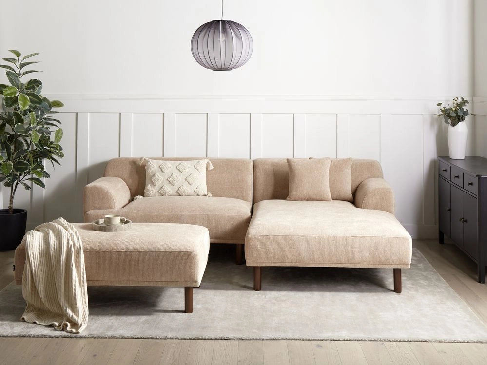 Divano ad angolo sinistro in tessuto beige lato sinistro con pouf e gambe in legno stile minimalista