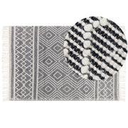 Tappeto in lana e cotone bianco e nero 160 x 230 cm, tessuto a mano a trama piatta con frange e motivo geometrico
