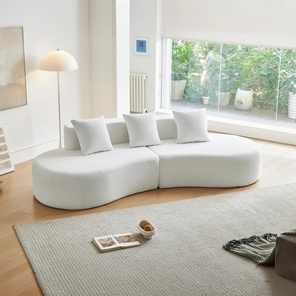 Divano ad angolo modulare a 3 posti con design curvo e cuscini decorativi, in tessuto bianco per soggiorno e appartamento