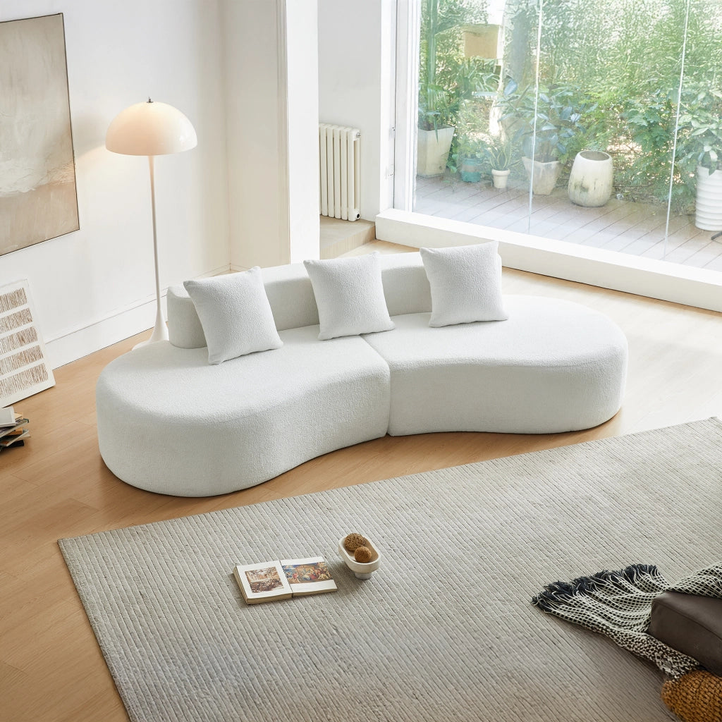 Divano ad angolo modulare a 3 posti con design curvo e cuscini decorativi, in tessuto bianco per soggiorno e appartamento