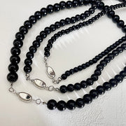 Nuova collana rotonda con perline nere e chiusura a lingotto.