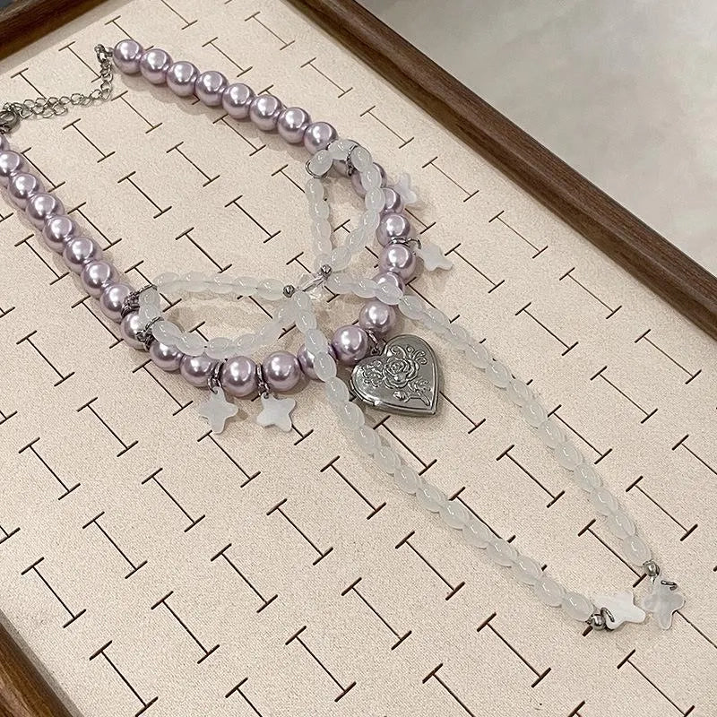Collana con fiocco fatta a mano con perle rosa e viola.