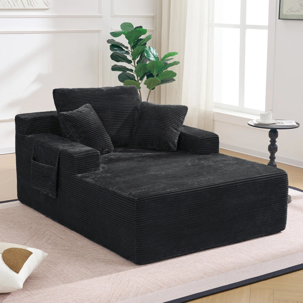 Divano compatto in corduroy nero con tasche laterali e cuscini decorativi