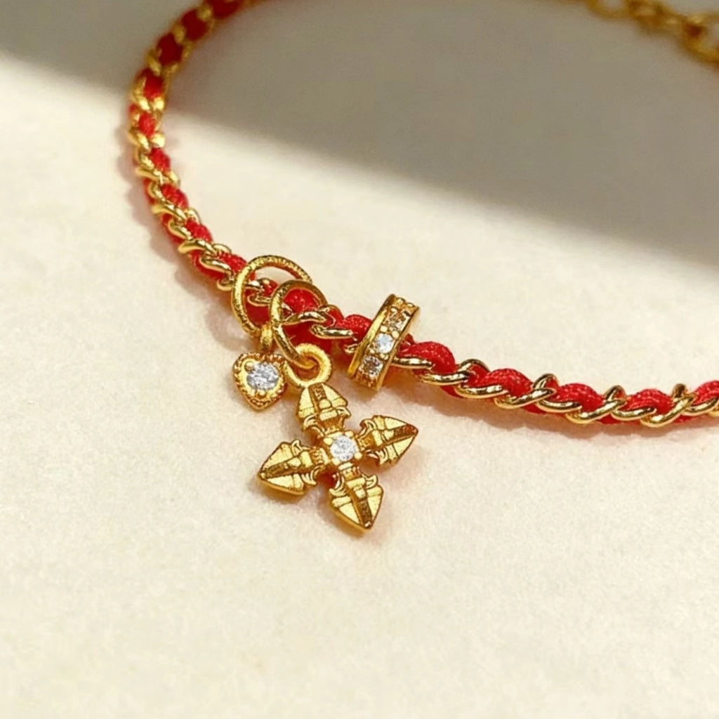 Bracciale intrecciato con zirconi a forma di croce e cuore, corda rossa e catena dorata