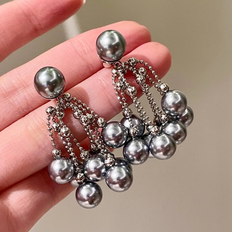 Orecchini a spillo in argento S925 con un'elegante e delicata nappa di perle grigie.