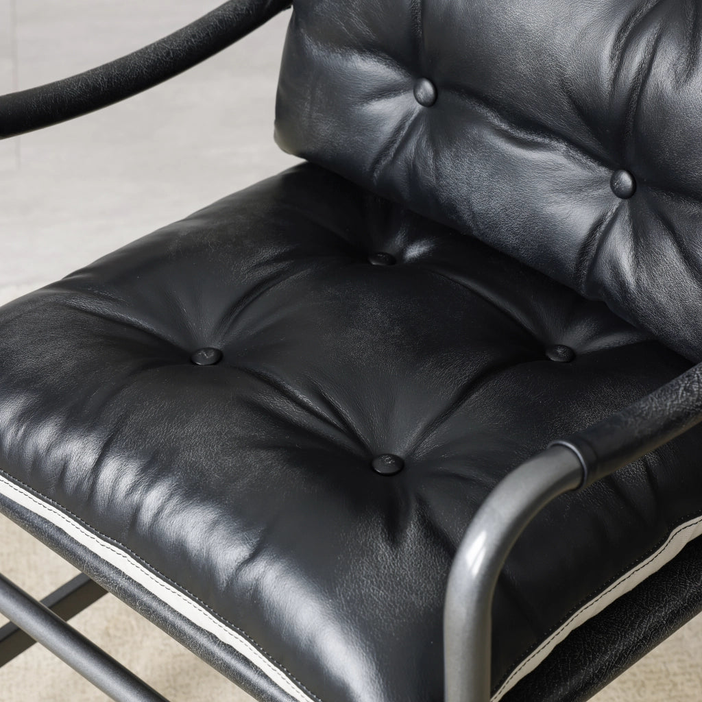Poltrona in pelle stile mid century moderno con struttura in metallo nero, seduta ampia e braccioli, nera