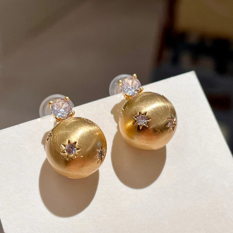 Piccoli e unici orecchini a lobo con zirconi spazzolati a forma di stella.