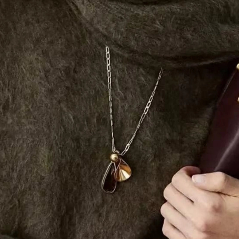 Collana vintage con pendente a goccia d'ambra e lunga catena marrone da donna.