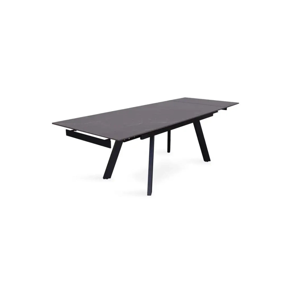 Tavolo da pranzo estensibile per 10 persone con piano in pietra nera della collezione LAROS. Struttura in metallo.