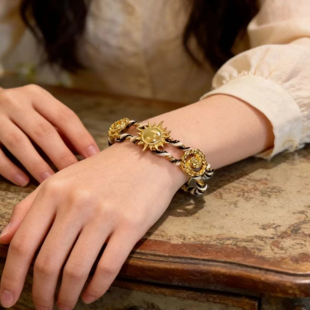 Bracciale regolabile da donna con girasoli in metallo traforato e intrecciato a mano.