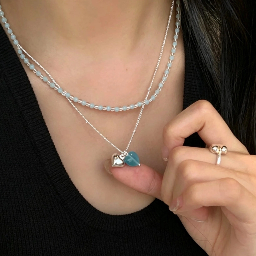 Collana girocollo a doppio strato con perline a forma di cuore blu, design unico.
