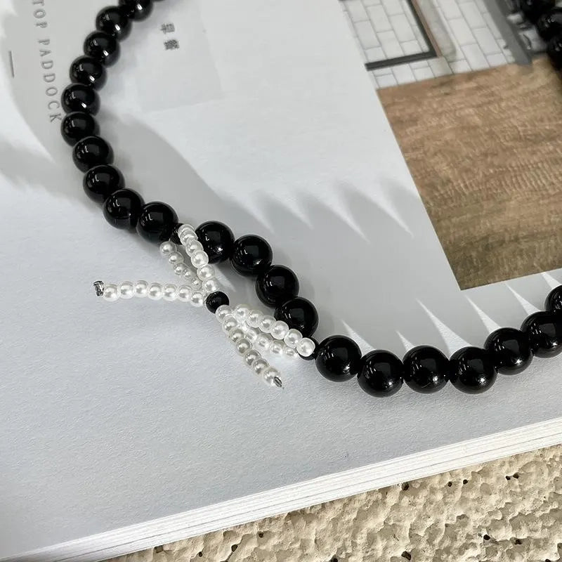 Collana con fiocco in corda nera e perline: regalo fatto a mano per donna.