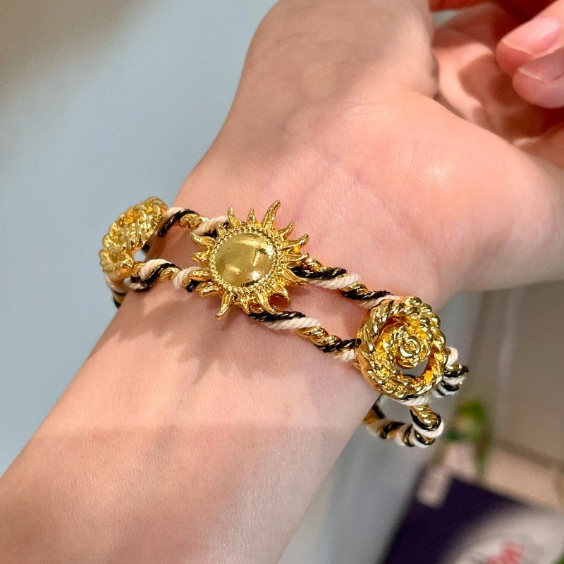 Bracciale regolabile da donna con girasoli in metallo traforato e intrecciato a mano.