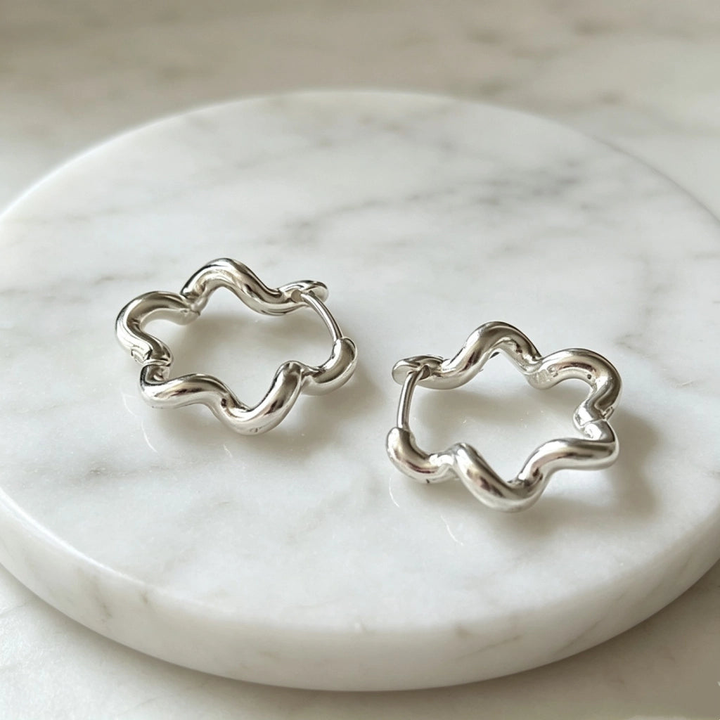 Orecchini a forma di fiore ondulato, minimalisti e dalle linee fredde.
