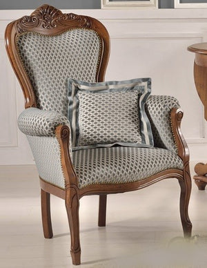 Poltrona imbottita in legno massello intagliata con fregi