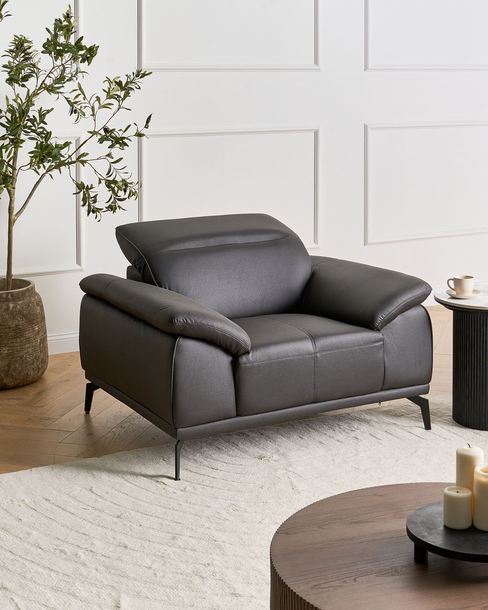 Poltrona in ecopelle con poggiatesta regolabile e gambe in metallo, colore nero stile moderno