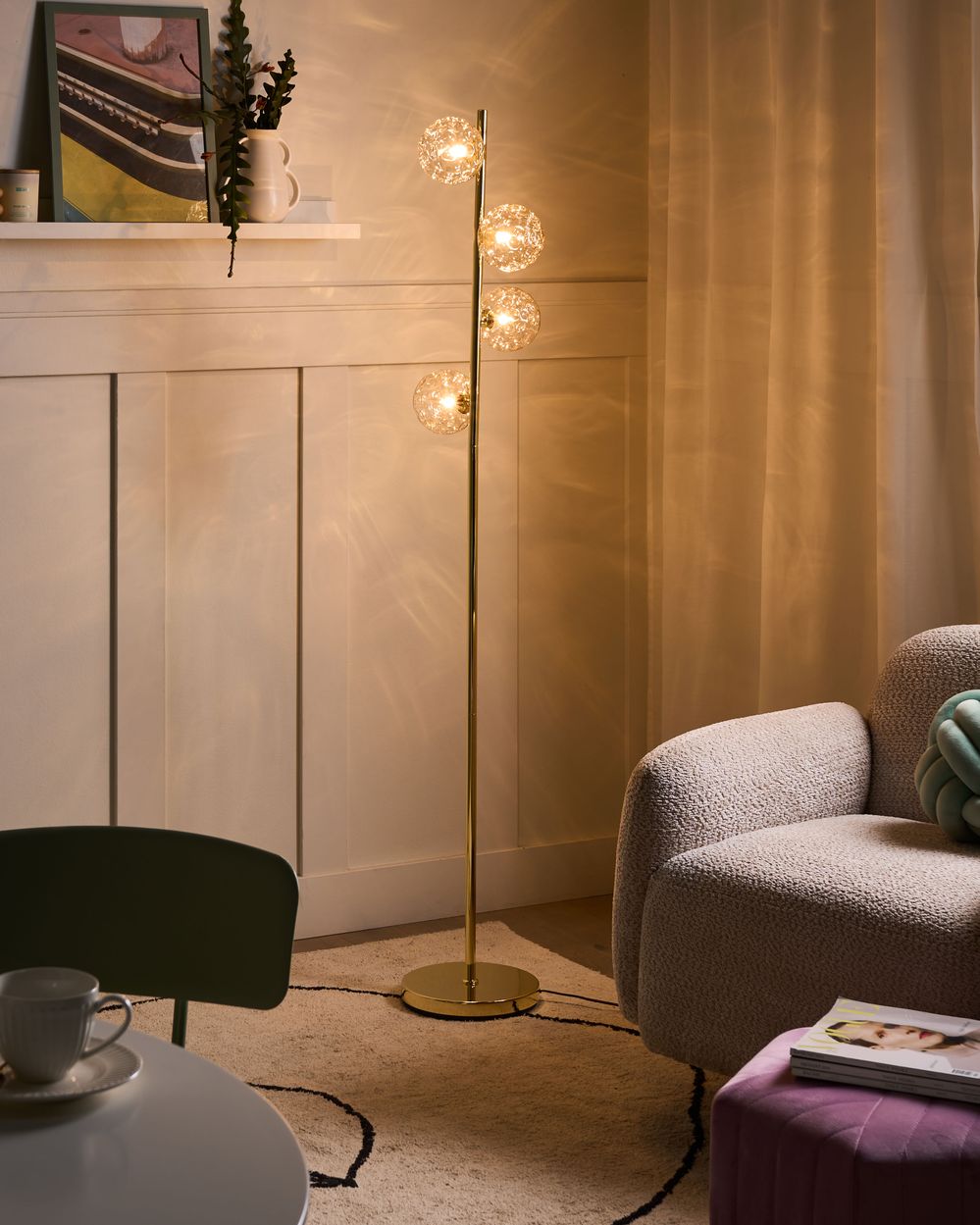 Lampada da terra in vetro beige con base in metallo dorato. Illuminazione per soggiorno dal look moderno e affascinante.