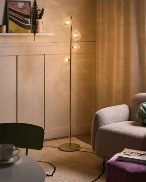 Lampada da terra in vetro beige con base in metallo dorato. Illuminazione per soggiorno dal look moderno e affascinante.