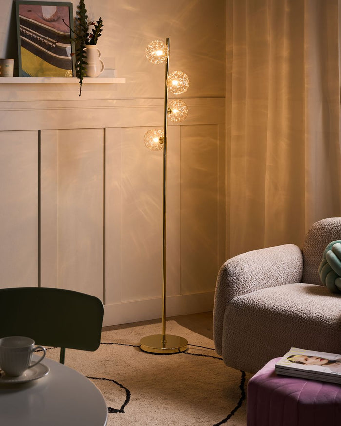 Lampada da terra in vetro beige con base in metallo dorato. Illuminazione per soggiorno dal look moderno e affascinante.