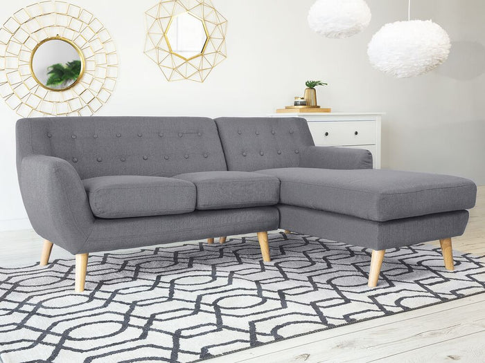 Divano ad angolo grigio chiaro imbottito con schienale capitonnè Chaise longue con gambe in legno chiaro Soggiorno minimalista scandinavo